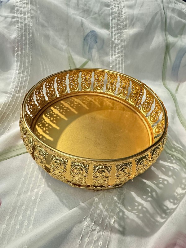 round, golden metal decorative tray or fruit basket